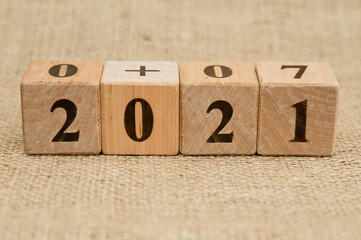 Happy New Year 2021 Christmas and New Year background. Symbol from number. Wooden cubes on canvas.
