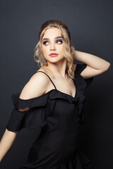 Fototapeta premium Young perfect woman wearing black dress on black background