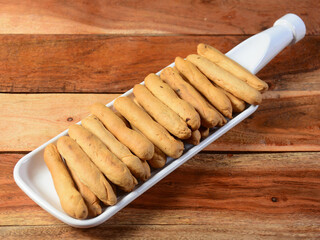 Freshly baked golden bread sticks on white plate, selective focus