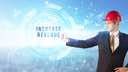 Handsome businessman with helmet drawing INCREASE REVENUE inscription, contruction business concept