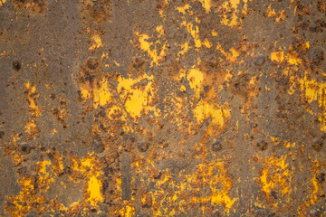 texture of a rusty metal surface with remains of yellow paint