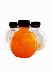 Three small bottles of water, juice or other water are placed on a white background containing two orange juice and two empty bottles.