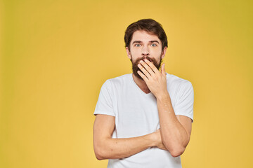 Man gesturing with hands emotions lifestyle white t-shirt yellow isolated background