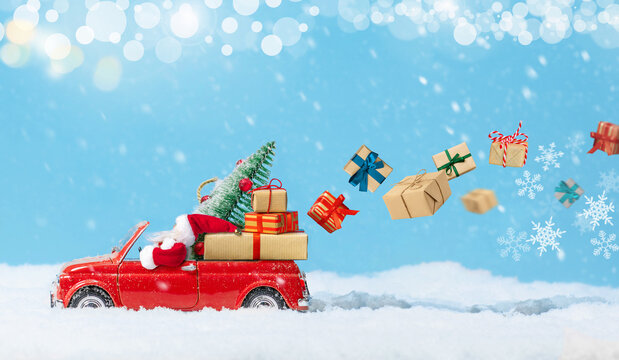 Santa Claus in Red car delivering christmas or New Year gifts at snowy background.