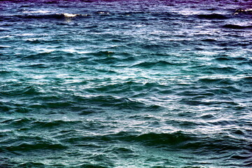 Gradient blue and turquoise color of wavy sea surface with sparkling spots