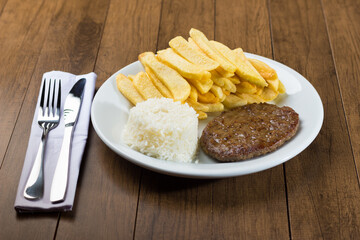 Tasty combination of hamburger accompanied by rice and fries. Gourmet Photo.