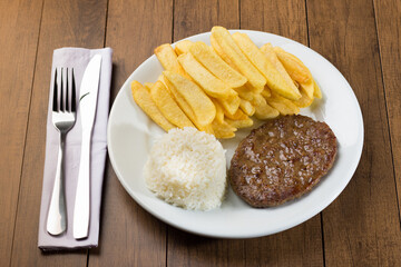 Photograph of Tasty combination of hamburger accompanied by rice and fries. Gourmet Photo.