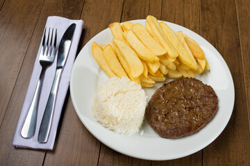 Photograph diagonal of Tasty combination of hamburger accompanied by rice and fries. Gourmet Photo.