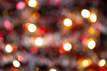 Christmas background with blur Golden lights of garlands in the bokeh. Red tinsel, Christmas tree. New Year. Copy space.