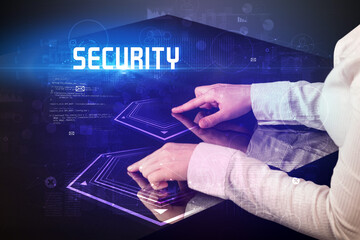 Hand touching digital table with SECURITY inscription, new age security concept