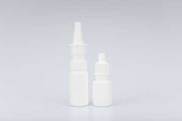 Unbranded white nasal and eye drops on light grey background