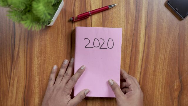 Concept showing of completion of 2020 dairy and starting 2021 new year with fresh book - concept of new year, new start or beginning