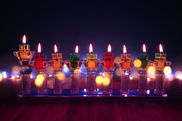 image of jewish holiday Hanukkah background with crystal menorah (traditional candelabra) and oil...