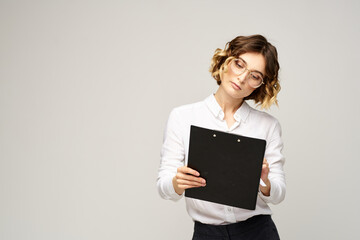 Business woman with a folder of documents on a light background cropped view and shirt suit