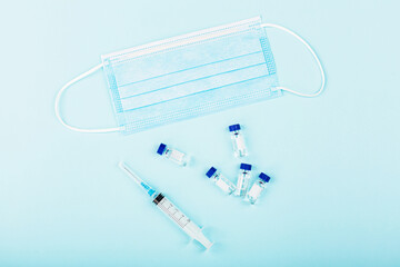 Flat lay of coronavirus covid-19 vaccine with syringe, face mask. Mockup with copy space, top view, overhead