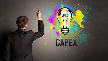 businessman drawing colorful light bulb with CAPEX inscription on textured concrete wall, new business idea concept