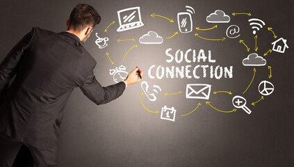 businessman drawing social media icons with SOCIAL CONNECTION inscription, new media concept