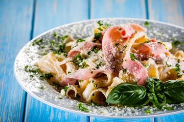 Pasta carbonara on white plate on wooden table
