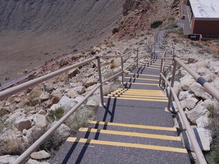 Downward view of the concrete stairs with railings at the rim of Meteor Crater, formerly known as...