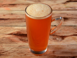 Glass of peach ice tea on rustic wooden background