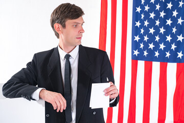American politician. Man on background of American flag. Young male politician from USA. Concept -...