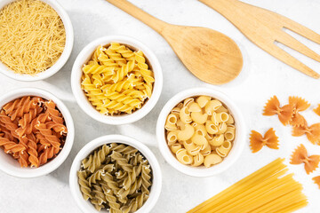 Top view of bowls with assorted uncooked pasta
