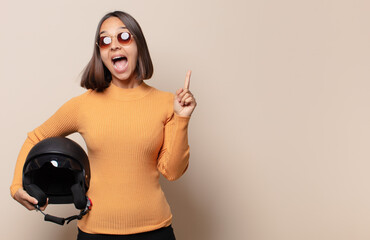 young woman feeling like a happy and excited genius after realizing an idea, cheerfully raising...