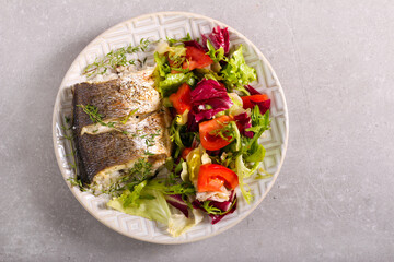 Baked sea bass fish with salad