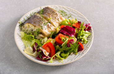 Baked sea bass fish with salad