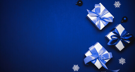 Christmas sale. White gift with cyan bow, blue balls and winter tree in xmas decoration on azure...