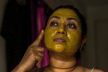 Close up of a woman with cosmetic facial mask all over her face.