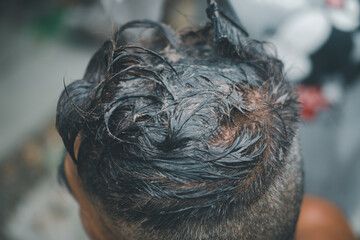Old man dyes his hair in home. Black color hair