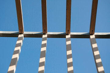 wooden beams of the frame under construction against the blue sky. High quality photo