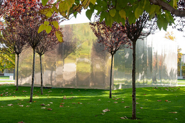 the metal facade of the building, which stands in a park among trees on the lawn. High quality photo
