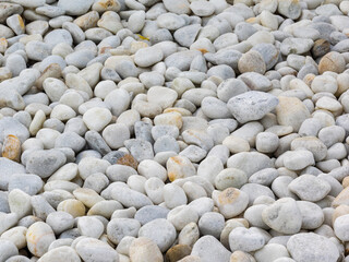 selective focus of a random  array of sun bleached limestone pebbles on the sea shore forming a stony beach or bed of a river