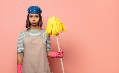 young woman housekeeper feeling sad and whiney with an unhappy look, crying with a negative and...