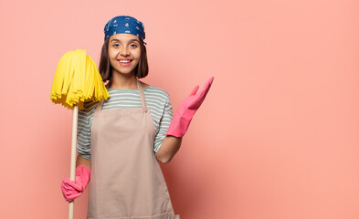 young woman housekeeper feeling happy, surprised and cheerful, smiling with positive attitude,...