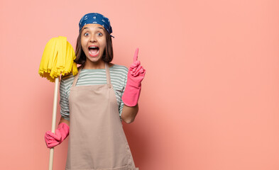 young woman housekeeper feeling like a happy and excited genius after realizing an idea, cheerfully...