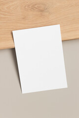 White invitation card mockup on a beige table. 5x7 ratio, similar to A6, A5.