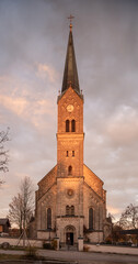Obraz premium Kirche im Abendlicht vor Wolke und blauem Himmel