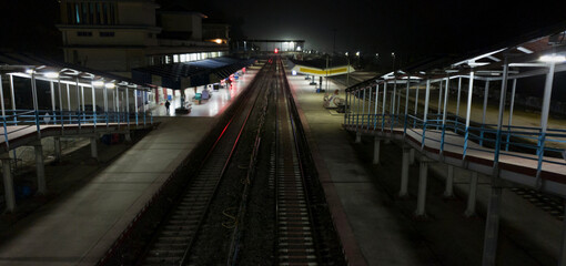 Empty railway platform at night with no people around.