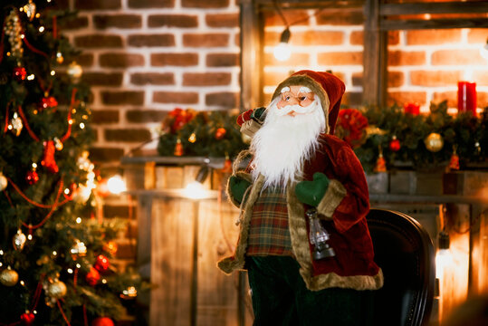 Christmas tree decorated with ornaments and lights on a warm background. New year's interior in the loft style. Santa Claus wishes everyone a merry Christmas and happy holidays. greeting card, frame.
