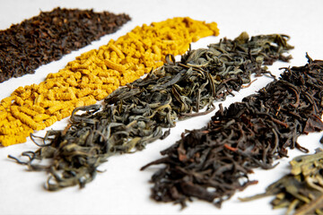 Various types of tea scattered on a light background. Assorted tea