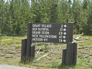 Directional roadsign to different destinations at Yellowstone National Park like Grant Village, Old...