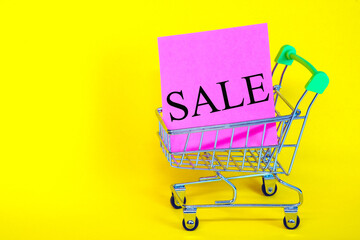 Sticker with the words discount, in the basket from the supermarket. Sales of products of all categories. Advertising design for the banner. Poster design. Yellow background.