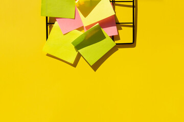 black metal grid with colorful notes on a neon yellow background