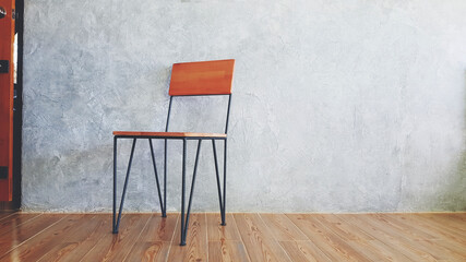Wooden chair in modern or classic style putting near door or entrance on the floor with gray or grey loft wall background with copy space. Object on rough wallpaper and Furniture design concept