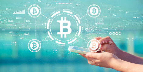 Bitcoin theme with person holding a white smartphone