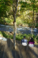 Blurred image of people relaxing on the terrace overlooking the mountain stream