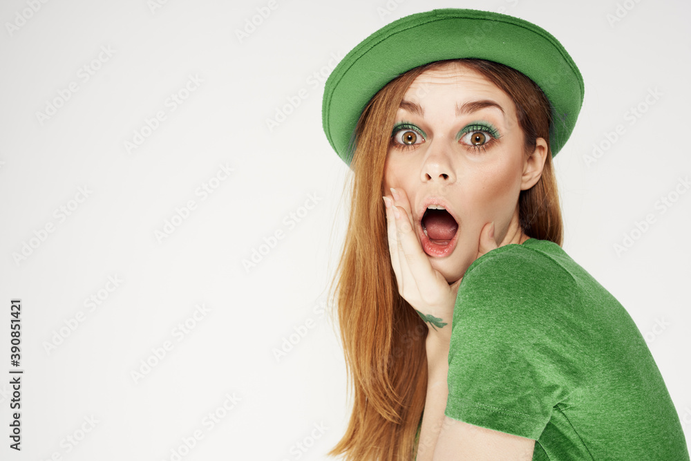 Wall mural shamrock happy girl in a green hat and a t-shirt on a light background st. patrick's day